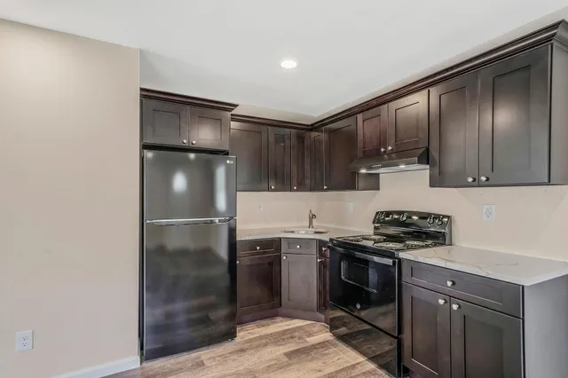 a kitchen with stainless steel appliances granite countertop a stove a refrigerator and a sink