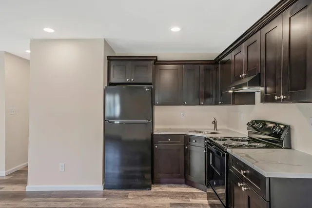 a kitchen with stainless steel appliances granite countertop a sink stove and refrigerator