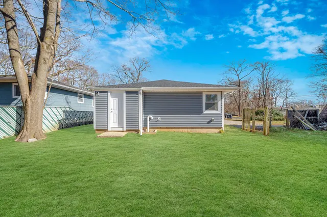 a backyard of a house with table and chairs