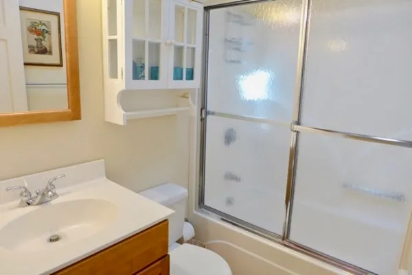 a bathroom with a sink and mirror with toilet