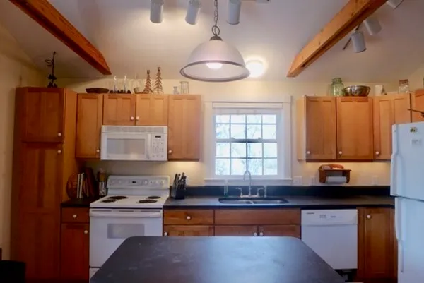 a kitchen with stainless steel appliances granite countertop a sink a stove and a refrigerator