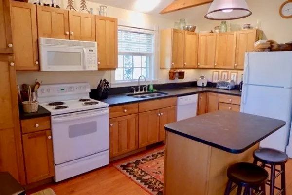a kitchen with a stove a sink cabinets and a refrigerator