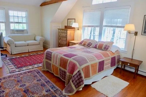 a bedroom with a bed and wooden floor