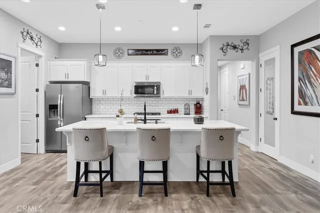 a kitchen with a dining table chairs and sink