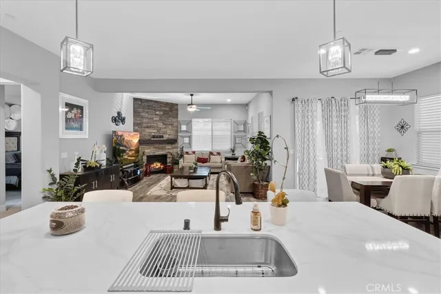 a kitchen with stainless steel appliances a refrigerator a sink dishwasher a oven with white cabinets and wooden floor