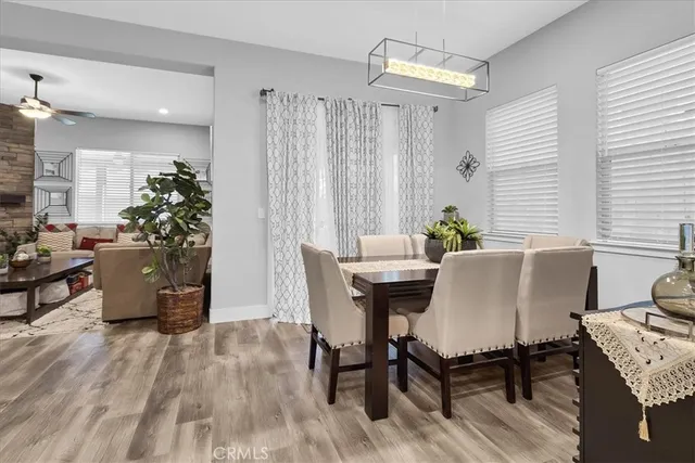 a kitchen with stainless steel appliances a table chairs refrigerator and sink