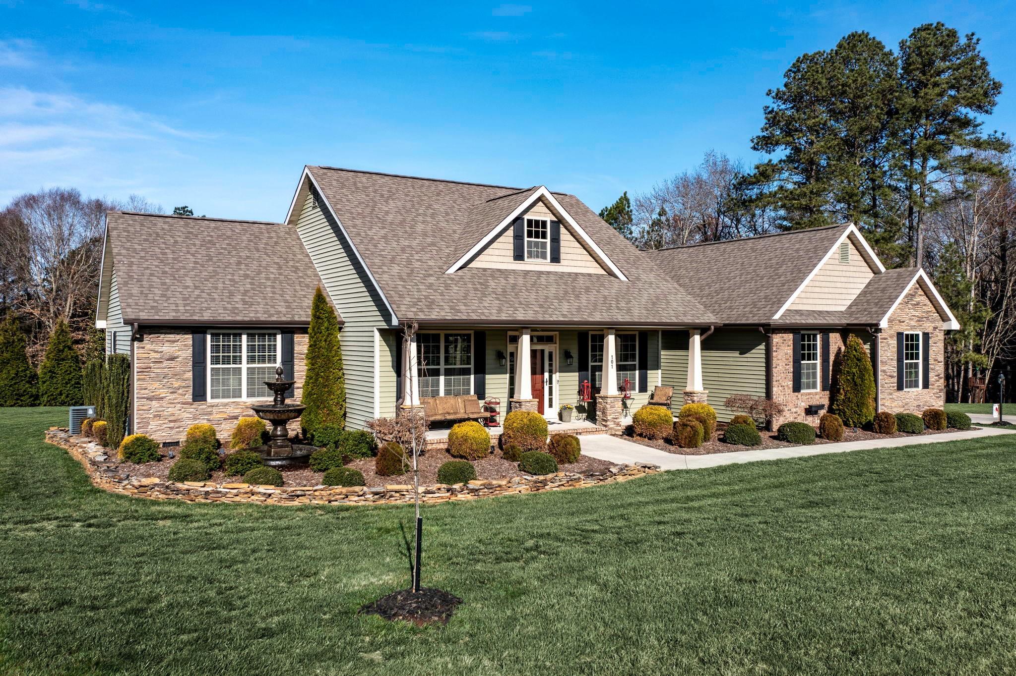 a front view of a house with garden and sitting area