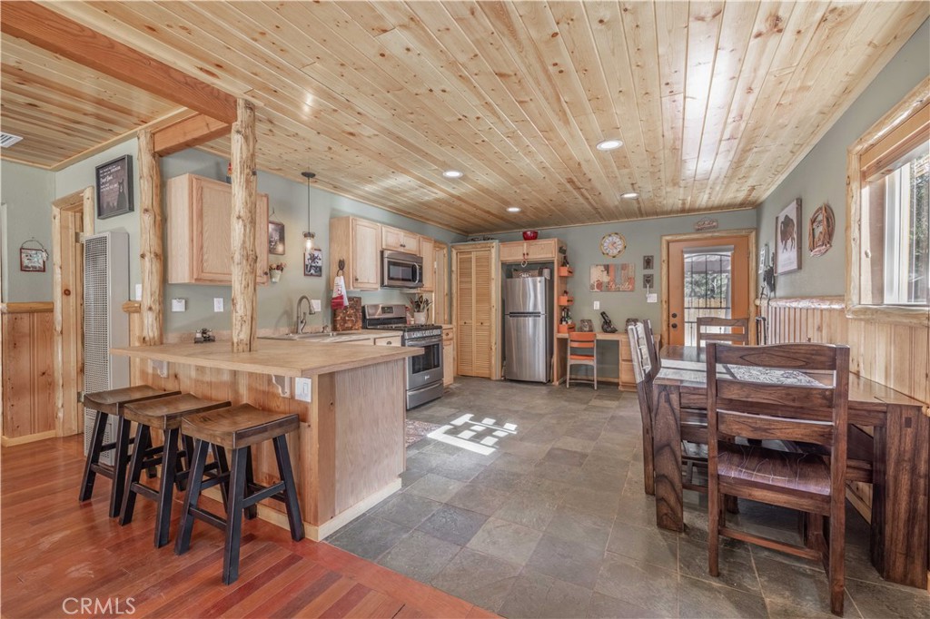 898 B Lane Big Bear City, CA 92314 - Photo 13 of 38 a kitchen with stainless steel appliances granite countertop a table chairs and a refrigerator
