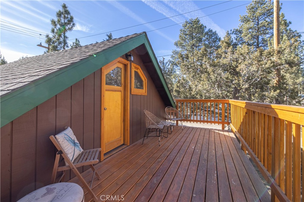 898 B Lane Big Bear City, CA 92314 - Photo 32 of 38 a balcony with wooden floor table and chairs
