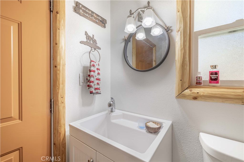 898 B Lane Big Bear City, CA 92314 - Photo 34 of 38 a bathroom with a sink mirror and vanity