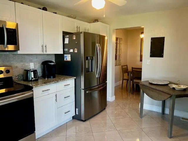 a kitchen with stainless steel appliances granite countertop a dining table and chairs