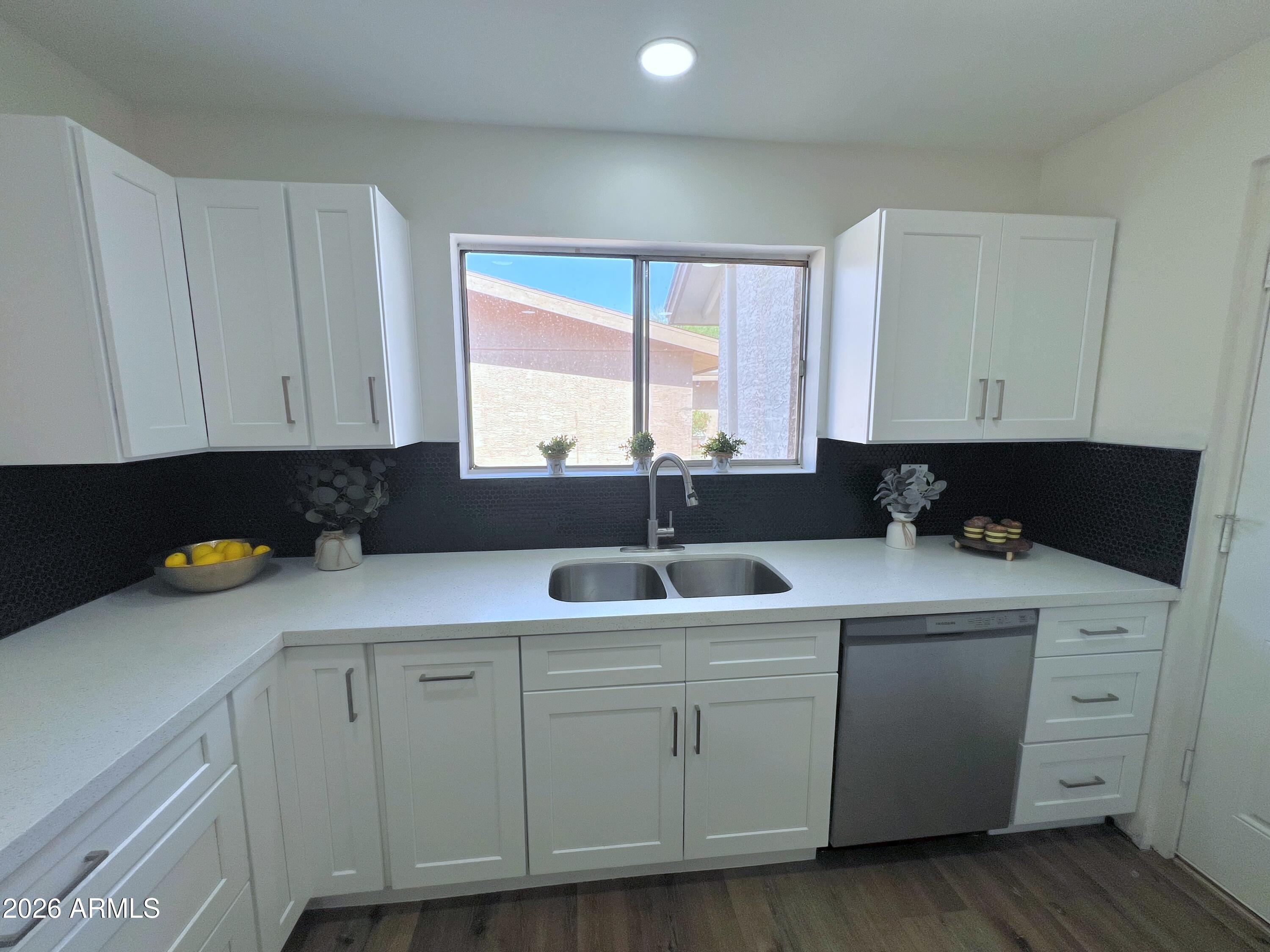 3818 West Ruth Avenue Phoenix, AZ 85051 - Photo 3 of 20 a kitchen with white cabinets and sink