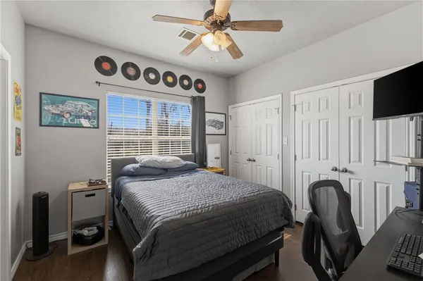 a bedroom with a bed and a flat tv screen on the dresser