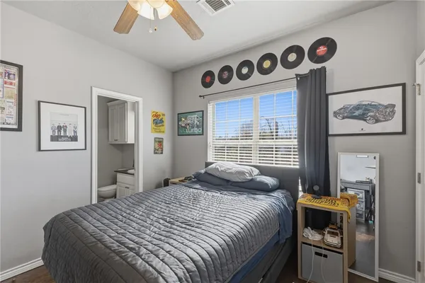 a bedroom with a bed and a large mirror on the dresser
