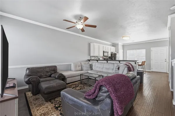 a living room with furniture white walls and wooden floor