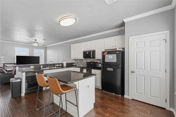 a kitchen with stainless steel appliances granite countertop a refrigerator and a stove top oven