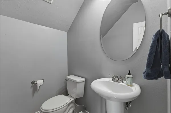 a bathroom with a sink a toilet and a mirror