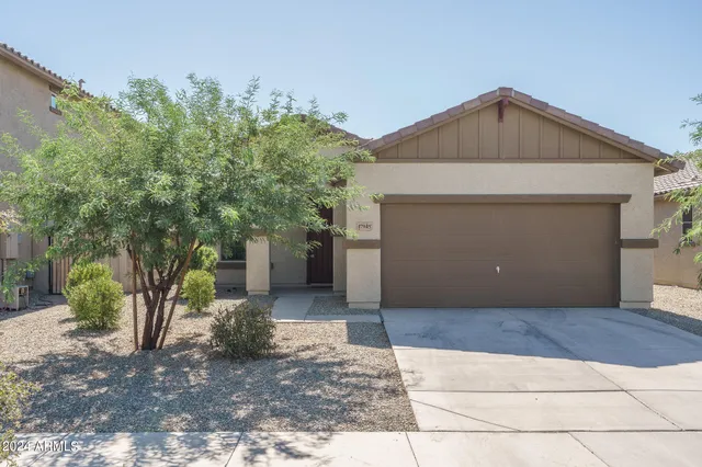 a front view of a house with a yard and trees