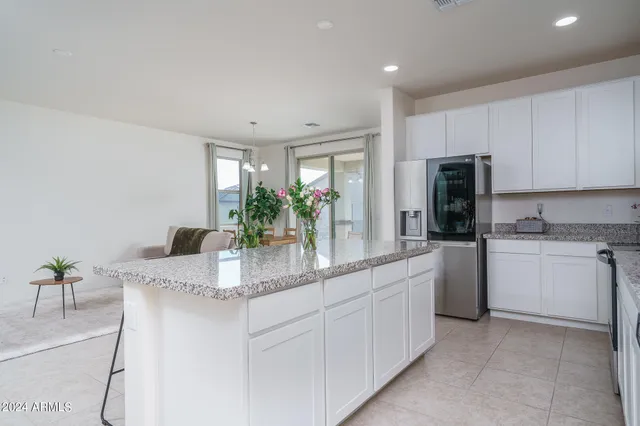 a kitchen with kitchen island granite countertop appliances a sink and cabinets