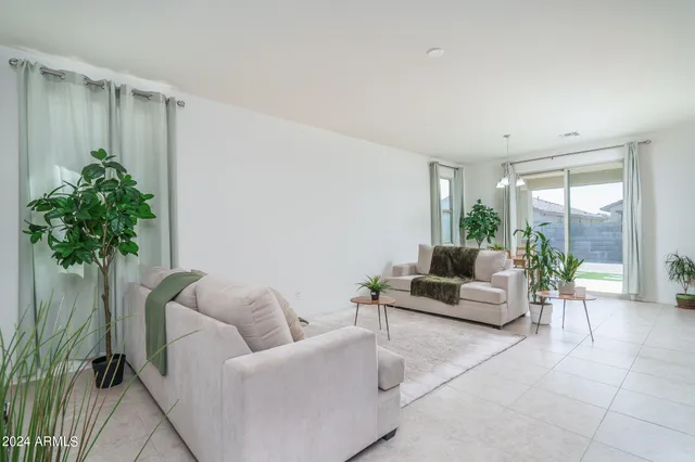 a living room with furniture plant and a large window