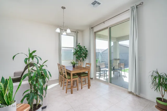 a dining room with furniture potted plants and a chandelier