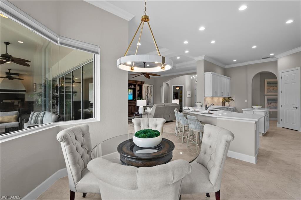 9774 Nickel Ridge Circle Naples, FL 34120 - Photo 11 of 50 a dining room with furniture a chandelier and window