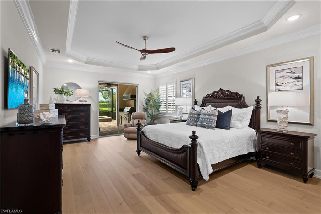 9774 Nickel Ridge Circle Naples, FL 34120 - Photo 13 of 50 a spacious bedroom with a bed and wooden floor