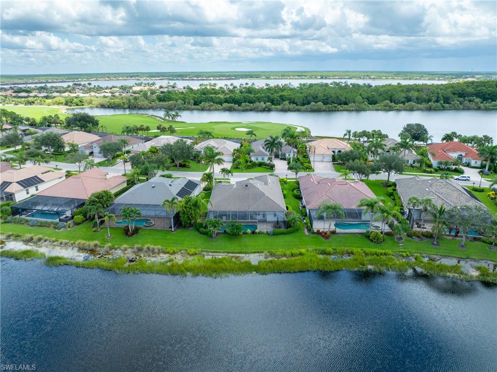 9774 Nickel Ridge Circle Naples, FL 34120 - Photo 36 of 50 a view of a lake with a house in the background