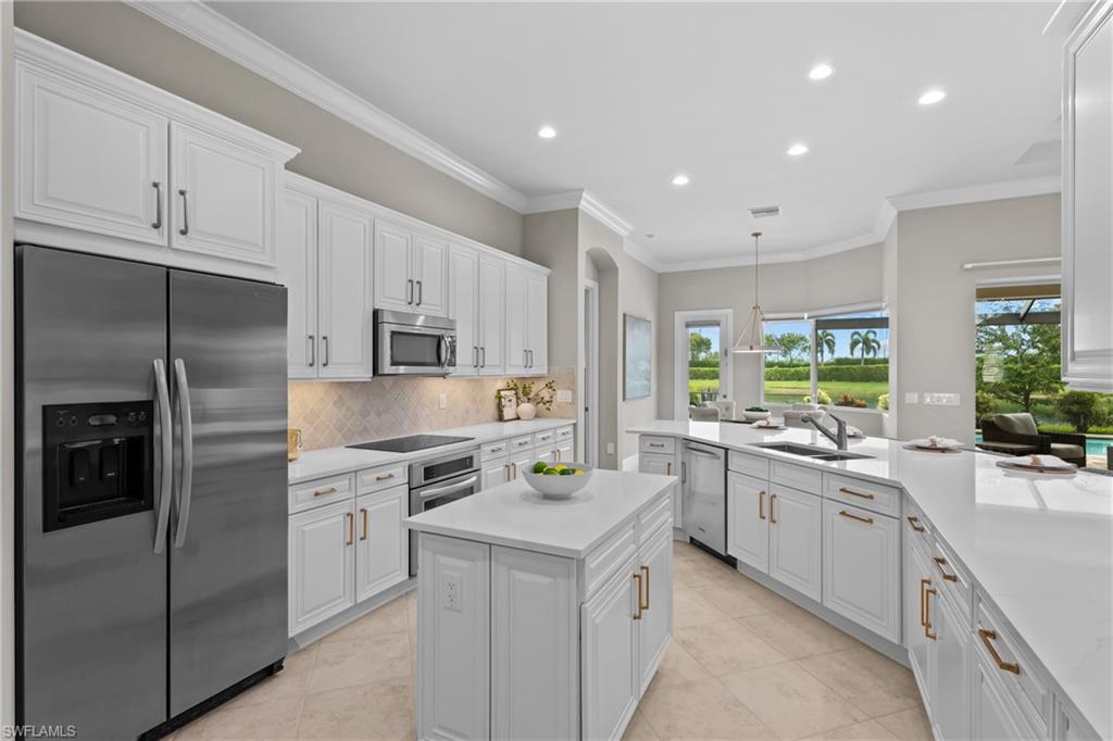 9774 Nickel Ridge Circle Naples, FL 34120 - Photo 9 of 50 a kitchen with a sink stove and refrigerator