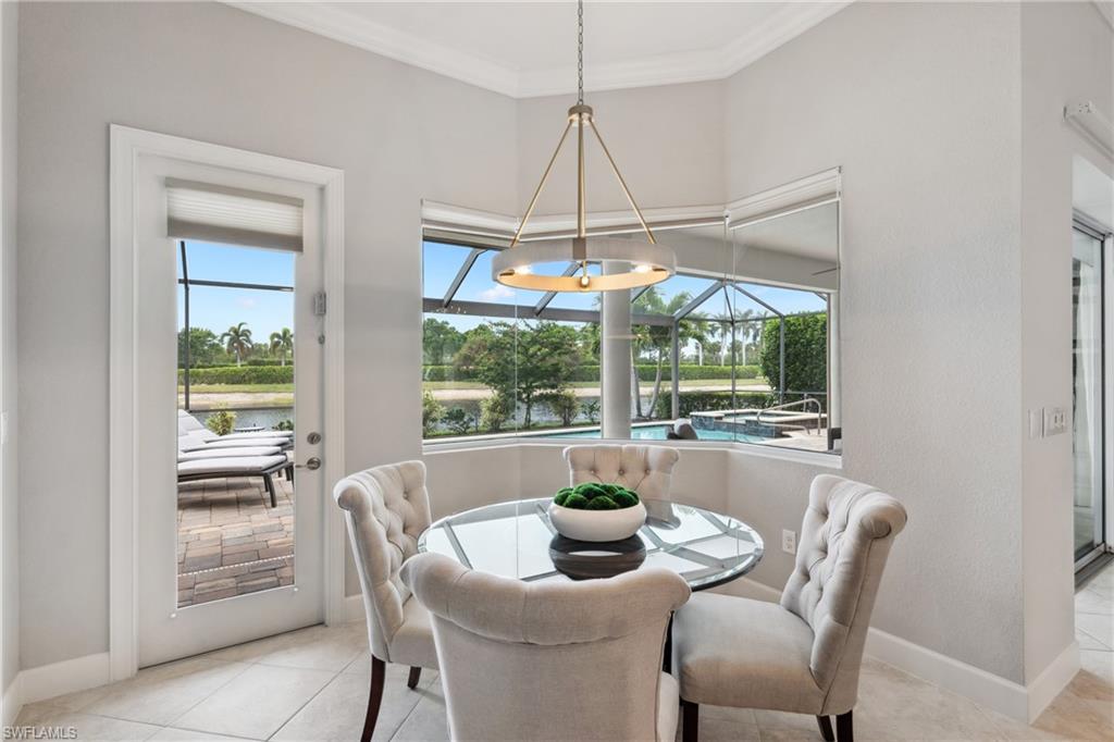 9774 Nickel Ridge Circle Naples, FL 34120 - Photo 10 of 50 a dining room with furniture a chandelier and a rug
