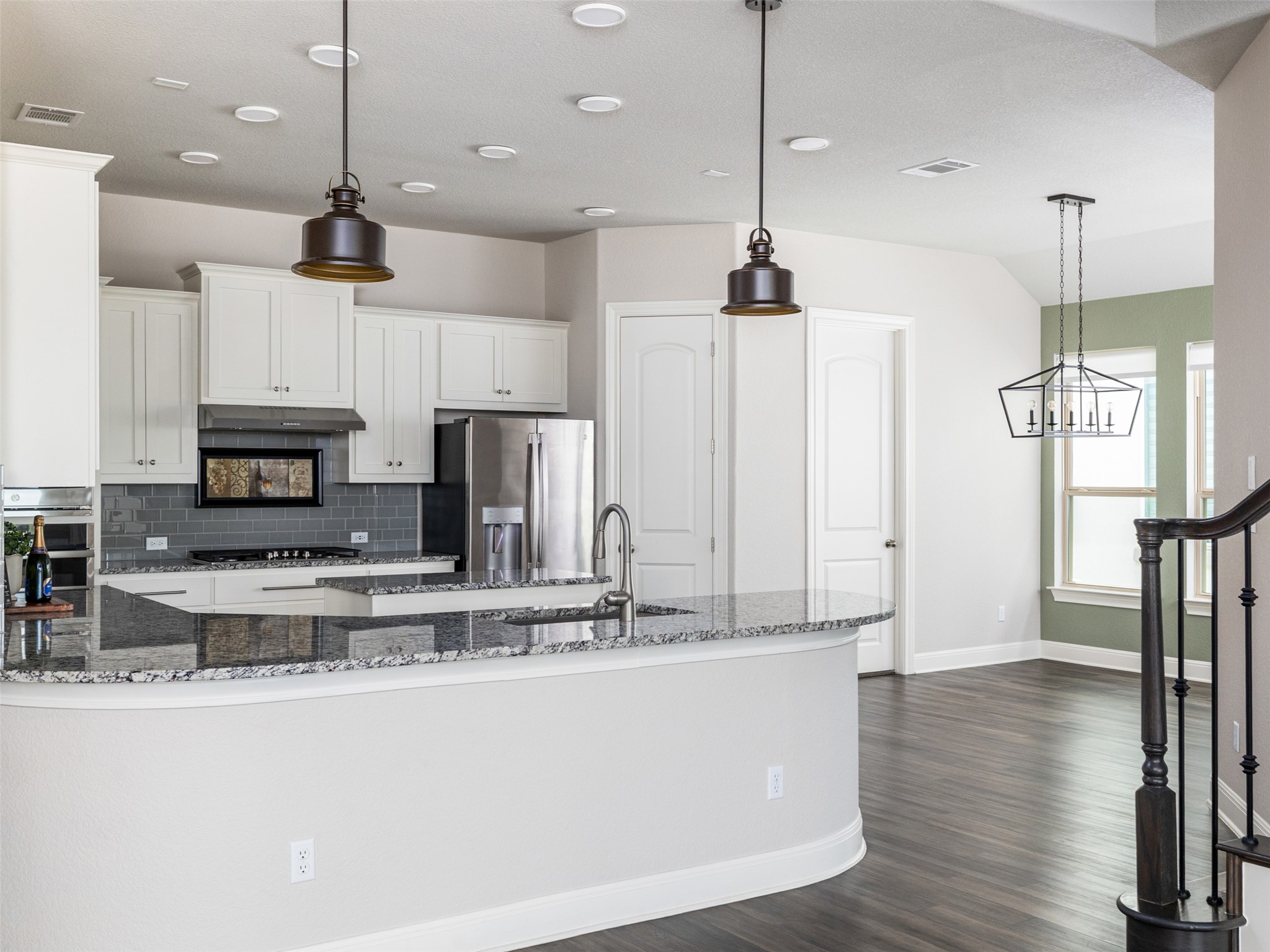 1329 Siena Sunset Road Leander, TX 78641 - Photo 16 of 40 A gourmet kitchen offers granite countertops and stainless steel appliances, opening to a spacious dining area.