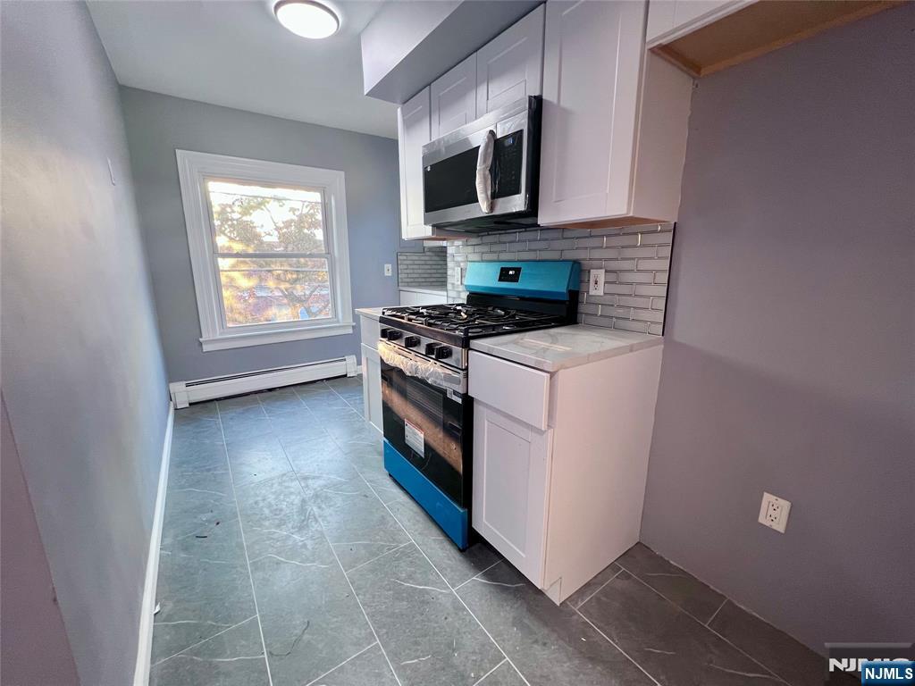 17 North Summit Street, Unit 2 Bergenfield, NJ 07621 - Photo 5 of 13 a kitchen with a stove top oven and cabinets
