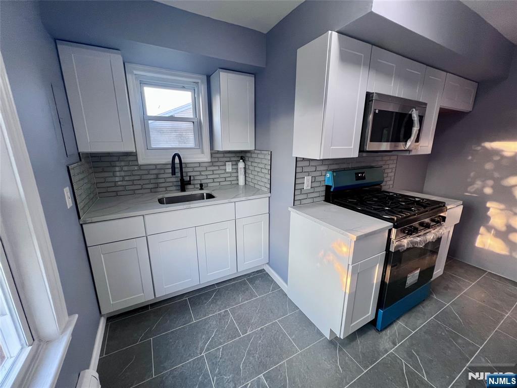 17 North Summit Street, Unit 2 Bergenfield, NJ 07621 - Photo 6 of 13 a kitchen with stainless steel appliances a sink stove and microwave