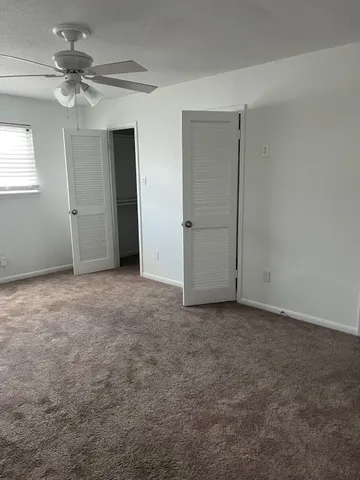 a view of an empty room with a ceiling fan
