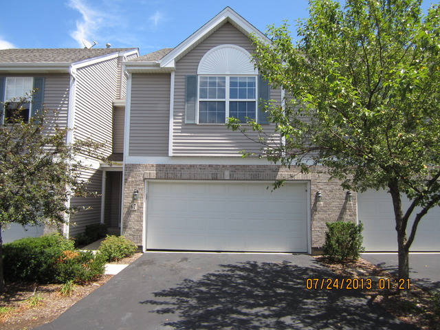 67 Colonial Court Streamwood, IL 60107 - Photo 22 of 25 a front view of a house with garden