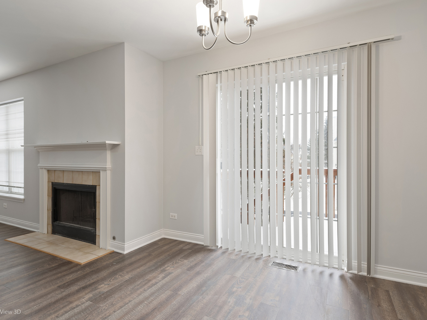 67 Colonial Court Streamwood, IL 60107 - Photo 6 of 25 an empty room with wooden floor fireplace and windows