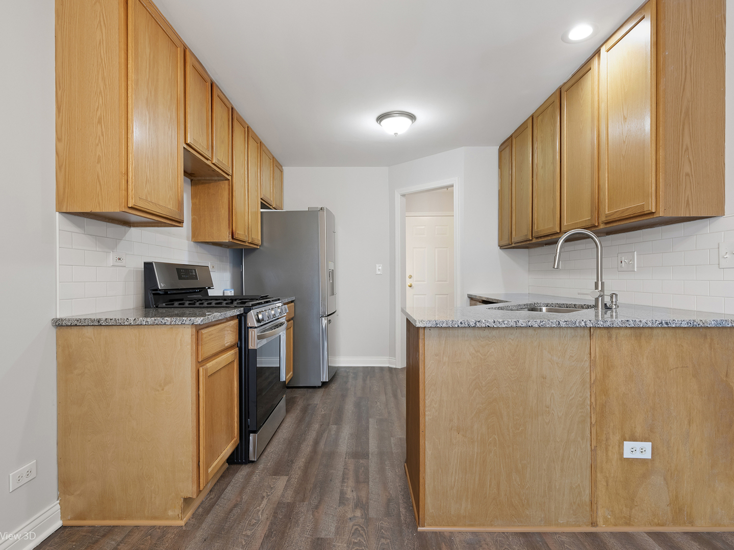 67 Colonial Court Streamwood, IL 60107 - Photo 7 of 25 a kitchen with stainless steel appliances granite countertop wooden cabinets a refrigerator a sink a stove and a microwave