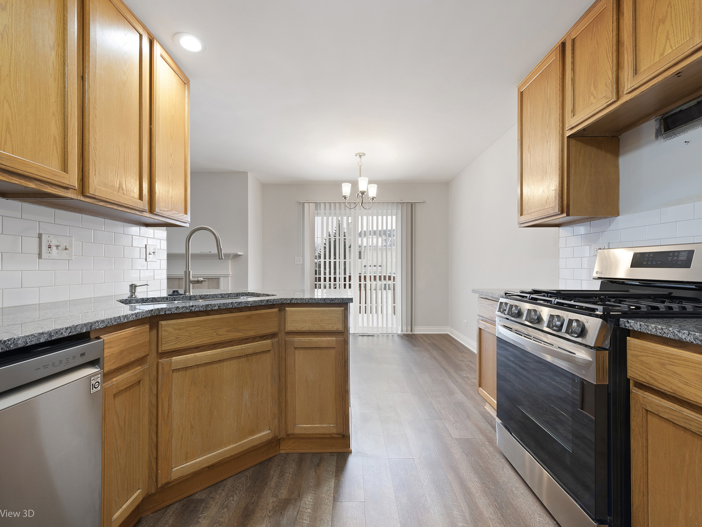 67 Colonial Court Streamwood, IL 60107 - Photo 8 of 25 a kitchen with stainless steel appliances granite countertop a sink stove and cabinets