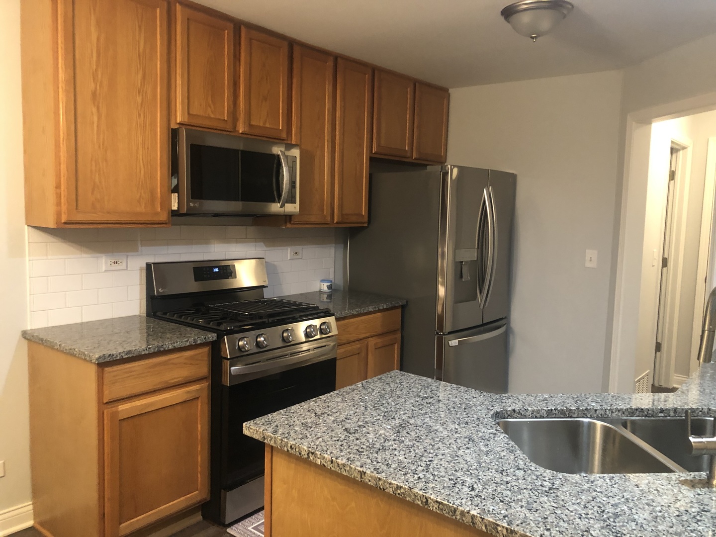 67 Colonial Court Streamwood, IL 60107 - Photo 10 of 25 a kitchen with stainless steel appliances granite countertop a sink stove and refrigerator