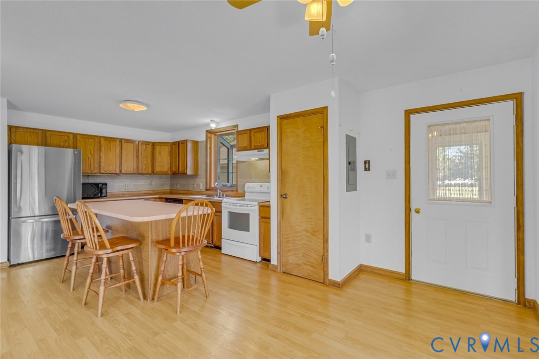 831 Fountain Gate Road Heathsville, VA 22473 - Photo 15 of 50 a kitchen with stainless steel appliances granite countertop a dining table chairs and a refrigerator