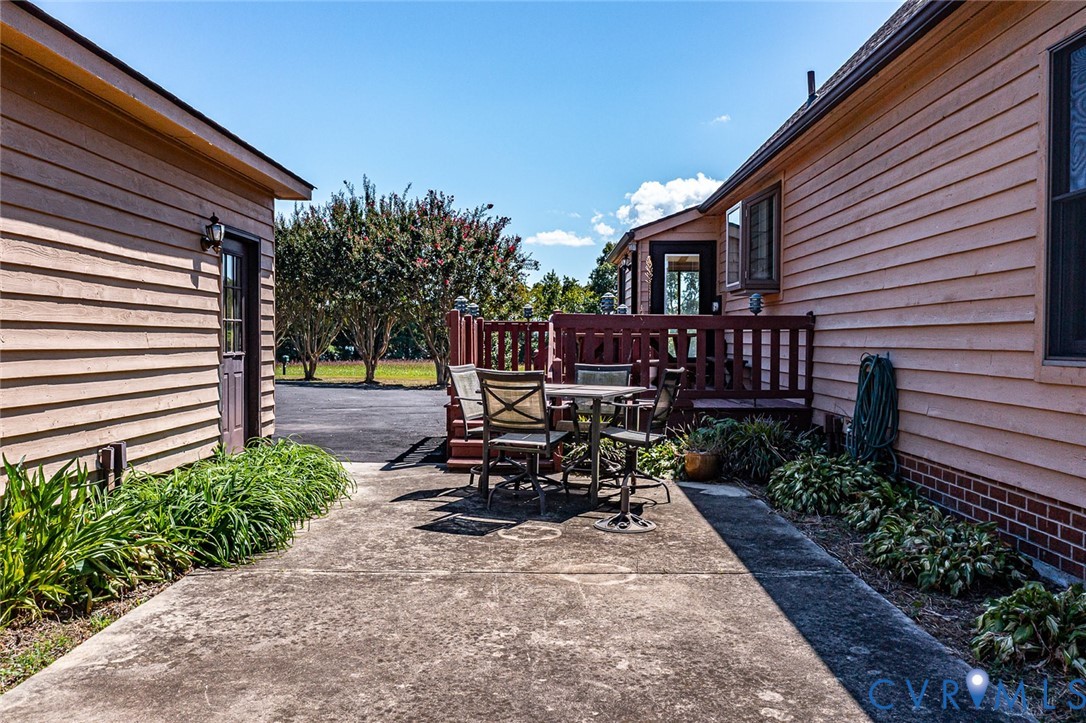 831 Fountain Gate Road Heathsville, VA 22473 - Photo 44 of 50 a view of a patio with table and chairs with plants and trees
