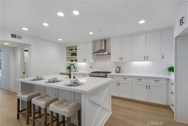 a kitchen with a sink dining table and chairs