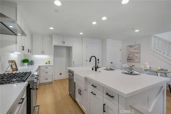 a kitchen that has a lot of cabinets in it and wooden floors