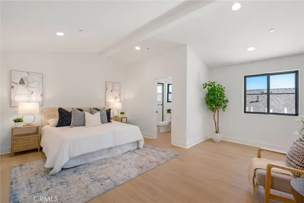 a bedroom with a large bed and a potted plant
