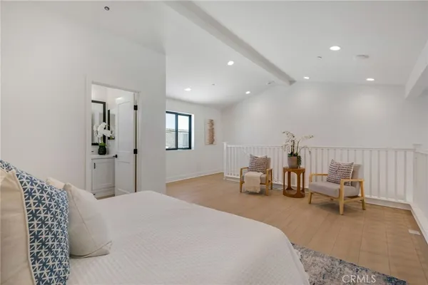 a spacious bedroom with a bed and a chair