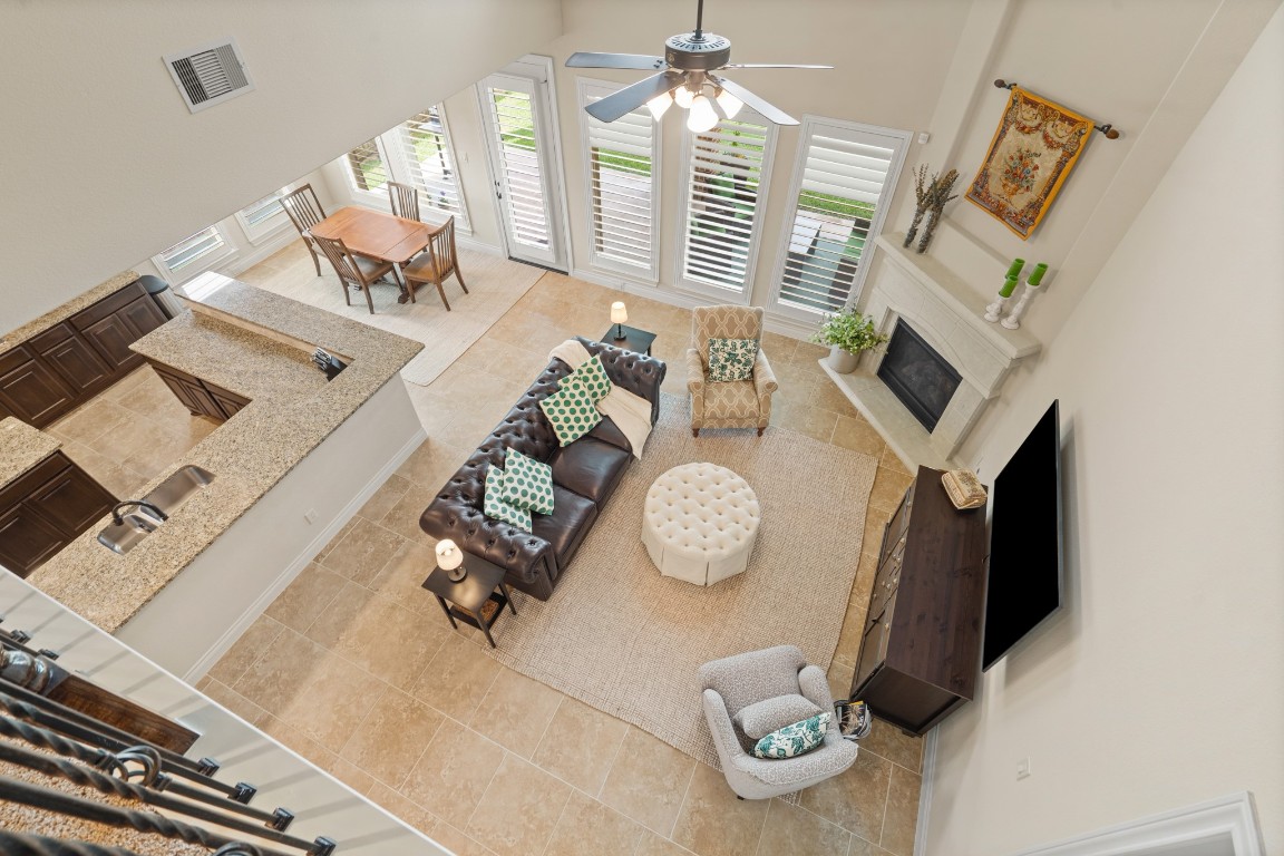 1607 Quail Ridge Drive Katy, TX 77493 - Photo 13 of 33 Whether it's a simple night in or entertaining family and friends, this home has ample open space for everyone to enjoy! This stunning open-concept home is filled with natural light, soaring ceilings, and beautiful tile flooring throughout. The inviting layout seamlessly connects the dining and living areas with an anchored fireplace to create family memories.