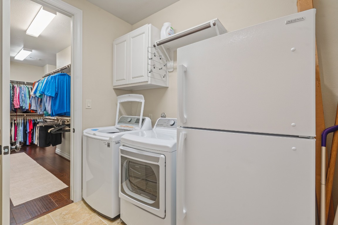 1607 Quail Ridge Drive Katy, TX 77493 - Photo 19 of 33 Storage meets style in this custom primary closet! Designed with ample space, this walk-in sanctuary keeps everything beautifully organized while adding a touch of luxury to your daily routine, and it conveniently connects to the laundry room.