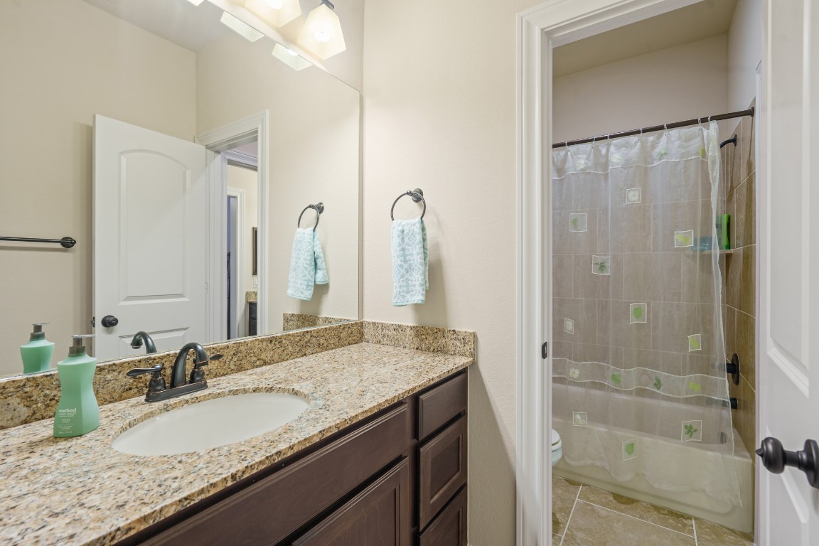 1607 Quail Ridge Drive Katy, TX 77493 - Photo 25 of 33 A Jack and Jill bathroom is the perfect set up for sharing! This private vanity area features an oversized vanity with granite countertops, a large mirror and plenty of storage.