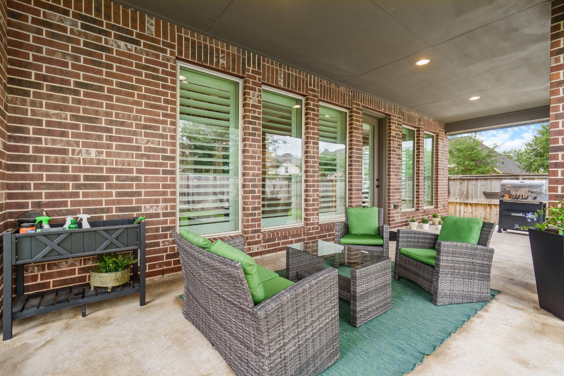 1607 Quail Ridge Drive Katy, TX 77493 - Photo 31 of 33 Step outside to enjoy the expansive backyard, complete with a covered patio and extended concrete area — the perfect setup for outdoor dining, lounging, or weekend barbecues.