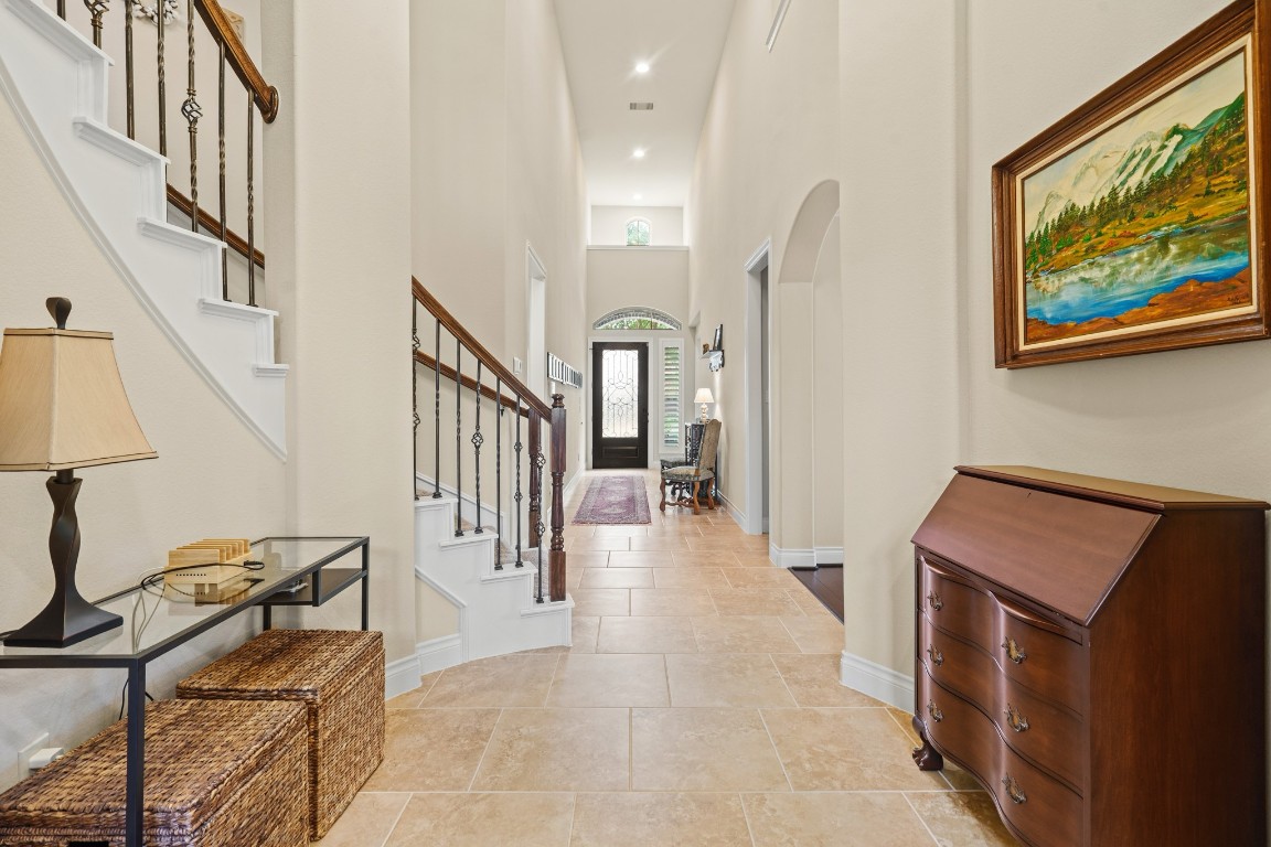 1607 Quail Ridge Drive Katy, TX 77493 - Photo 4 of 33 This elegant foyer features soaring ceilings, neutral toned tile floors, and a curved staircase with wrought iron details. This is a truly welcoming space filled with natural light, which encourages you and your guests to really feel at home here.